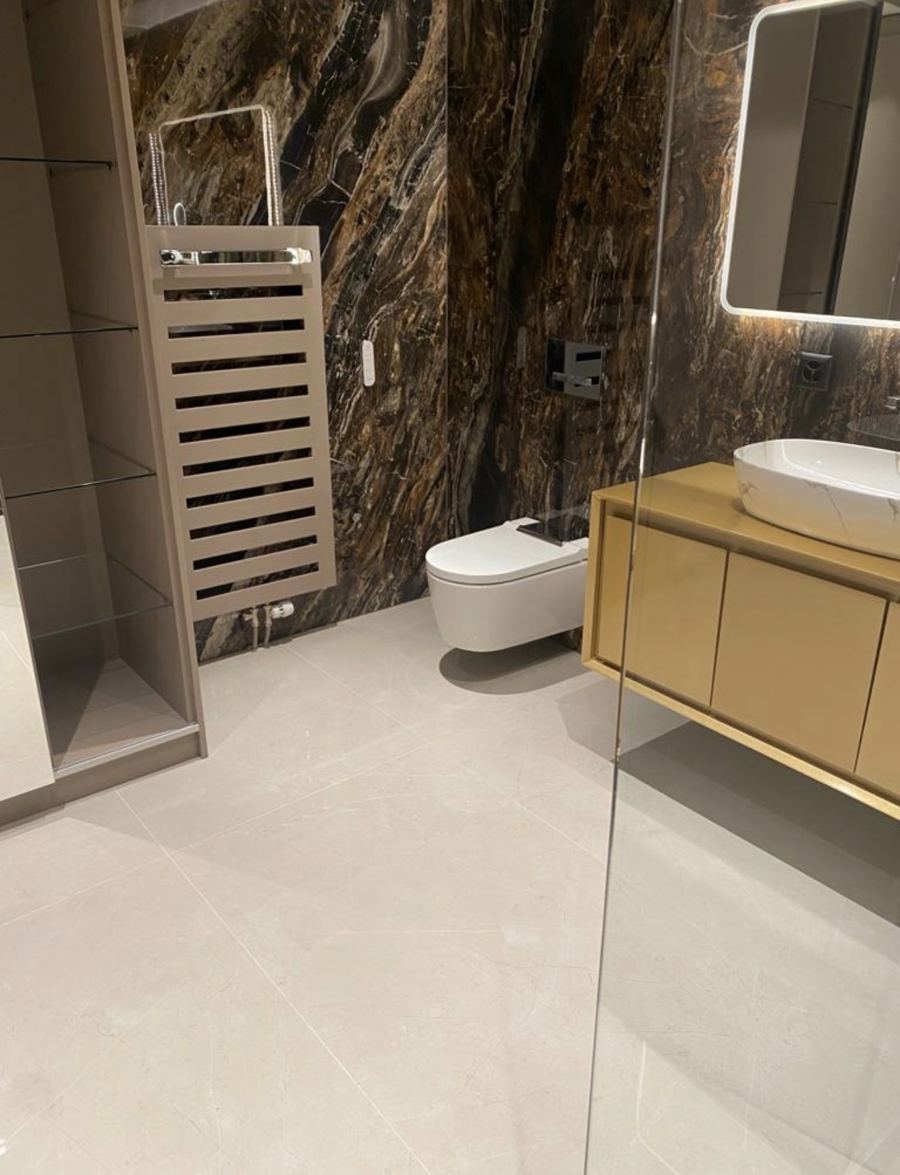 Salle de bain avec mur effet pierre brune et WC suspendu